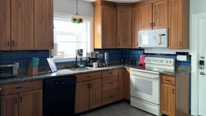 A kitchen with wooden cabinets, a microwave, a stove, and a dishwasher.