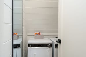A compact laundry room with a Kenmore washer and dryer, a small storage box, and a towel dispenser. - Luxe A-frame Hideaway, mountain views, hot tub, outdoor patio w/fireplace (Blairsville)
