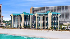 Un hôtel en bord de mer, avec plusieurs étages, des balcons et une vue sur la plage.