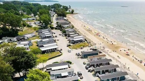 A coastal area with beach, ocean, and a row of mobile homes. - Sun Retreats Sherkston Shores (Port Colborne)