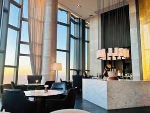 A modern hotel lobby with large windows, a reception desk, and seating areas. - Level 69 Bay Views & Japanese Soaking Tub (Melbourne)