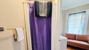 A bathroom with a shower curtain, a towel rack, and a toilet.