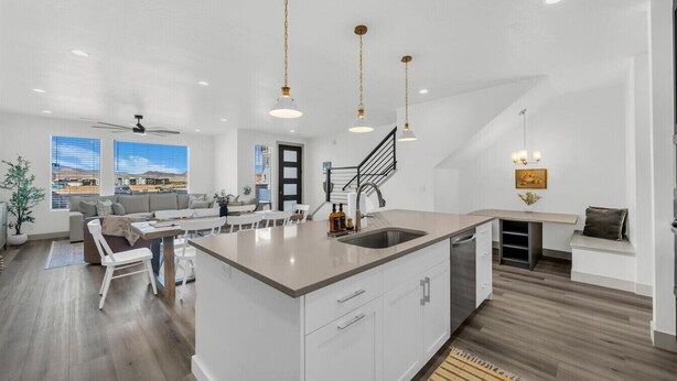 A modern kitchen with a central island, white cabinetry, and pendant lighting. - Sun-Filled Coastal Home | Lagoon Access| Hot Tub| Sleeps 12 (St. George)