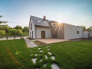 Una casa moderna con techo inclinado, entrada pavimentada y césped bien cuidado.