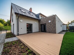 Una casa moderna con terraza, garaje y pared de ladrillo.