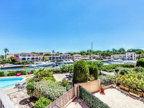 A marina with boats, a swimming pool, and buildings with balconies. - Le Phare by Interhome (Port Cogolin)