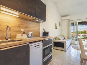 A modern kitchen with a built-in dishwasher, a coffee machine, and a kettle. - Le Phare by Interhome (Port Cogolin)