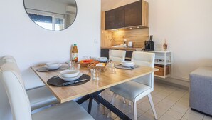 Eine moderne Küche mit Essbereich, inklusive Tisch gedeckt mit Tellern, Schüsseln und Gläsern, sowie einer Kaffeemaschine.