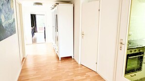 Passadís amb terres de fusta, parets blanques i portes que donen a altres espais.