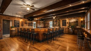 A bar area with wooden flooring, a central bar, multiple stools, and a ceiling fan. - Saratoga Vineyard + Private Golf Course + Tavern - Sleeps 25 (Greenwich)
