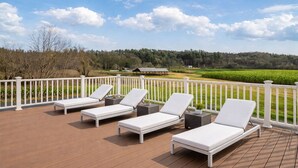 A deck with white lounge chairs and a white railing overlooking a green landscape. - Saratoga Vineyard + Private Golf Course + Tavern - Sleeps 25 (Greenwich)