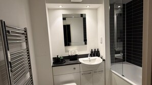 Ein modernes Badezimmer mit Toilette, Waschbecken und Dusche.