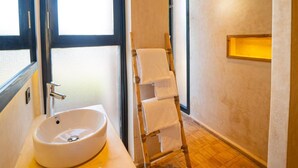 A bathroom with a large window, a sink, a towel rack, and a wooden ladder. - Baberrih (Moulay Bouzarqtoune)