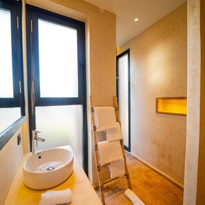 A bathroom with a large window, a sink, a towel rack, and a wooden ladder. - Baberrih (Moulay Bouzarqtoune)