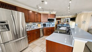 Een moderne keuken met roestvrijstalen apparatuur, houten kastjes en een groot eiland.
