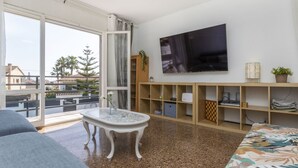 A modern living room with a large TV, a dining table, and a sofa. - Mi Capricho by Interhome (Calafell)