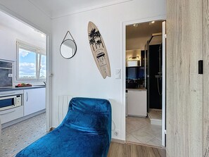 Een moderne keuken met witte kasten, een magnetron en een raam met uitzicht.