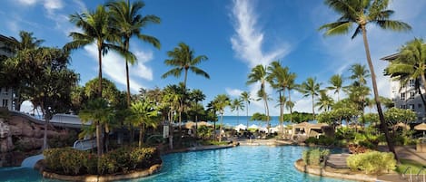 A pool surrounded by palm trees and a clear sky.