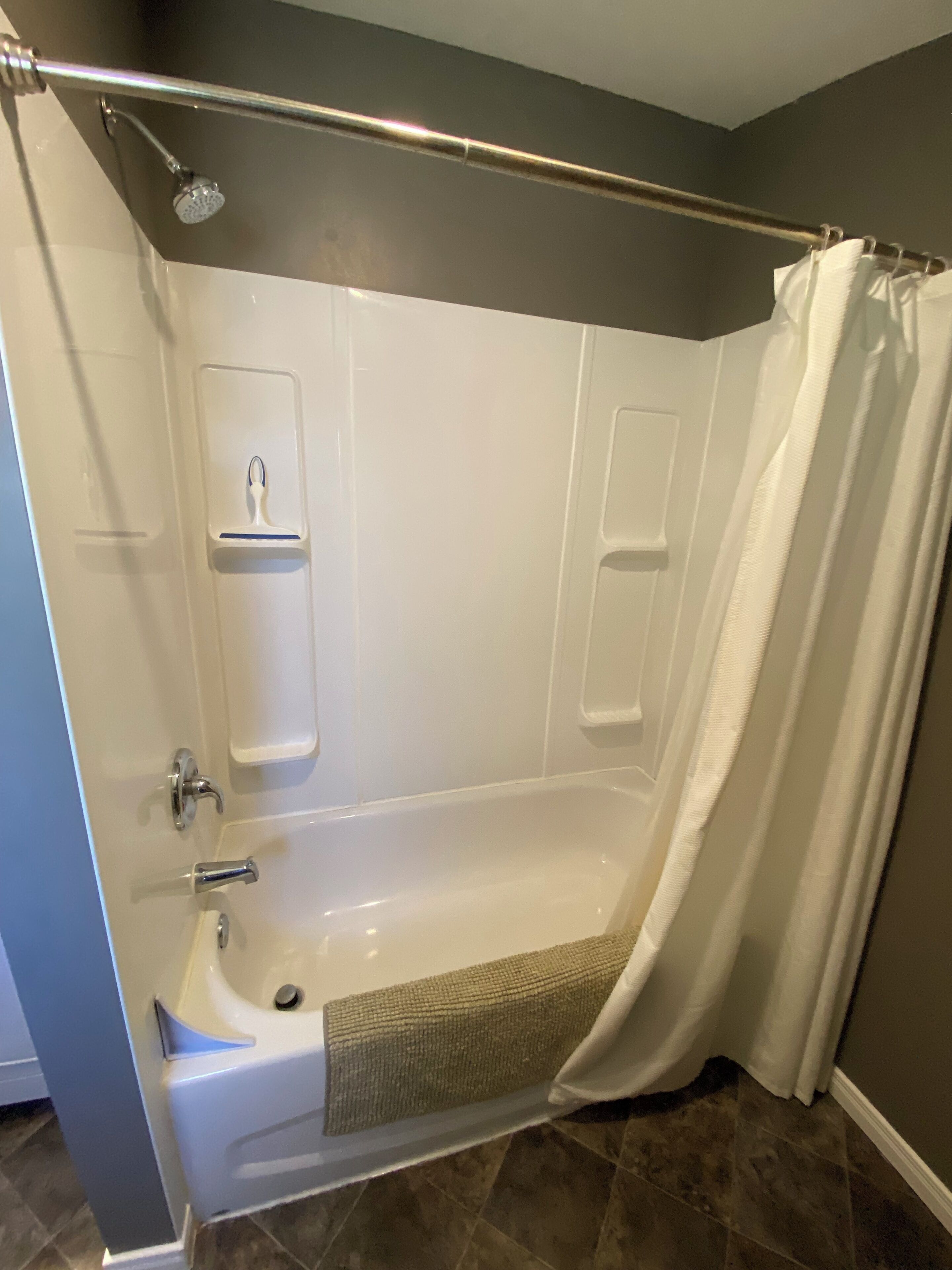 Une salle de bain avec une baignoire, une douche et un porte-serviettes.