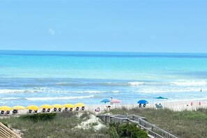 A beach with umbrellas and a wooden walkway. - Mayor's Penthouse: Oceanfront luxury w/elevator 4BR (Carolina Beach)
