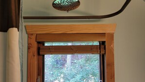 A bathroom with a shower, a window with a view of trees, and a towel rack. - Eco-Garden: Rural Beauty in recreation heaven. (Central Kootenay E)