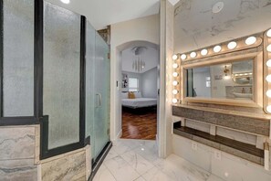 Ein Badezimmer mit Waschtisch, Spiegel und Beleuchtung.