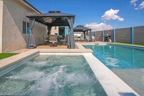 A swimming pool with a hot tub, lounge chairs, and a covered seating area. - Jackpot 6BR w/ Arcade • Vegas Fun Near the Strip (North Las Vegas)