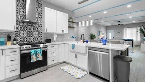 A modern kitchen with white cabinetry, a stainless steel oven, and a dishwasher.