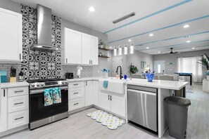 A modern kitchen with white cabinetry, a stainless steel oven, and a dishwasher. - Jackpot 6BR w/ Arcade • Vegas Fun Near the Strip (North Las Vegas)