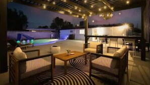 An outdoor patio area with a pool, seating, and a bar. - Radiant Pool Retreat: 4BR NLV Getaway (North Las Vegas)