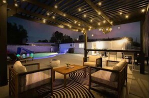An outdoor patio area with a pool, seating, and a bar. - Radiant Pool Retreat: 4BR NLV Getaway (North Las Vegas)