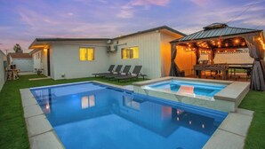 Propiedad residencial con piscina, zona de estar al aire libre y terraza cubierta.