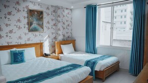 A hotel room with two beds, a nightstand, a window with curtains, and a floral wallpaper. - Bohemia Hotel (Ho Chi Minh City)