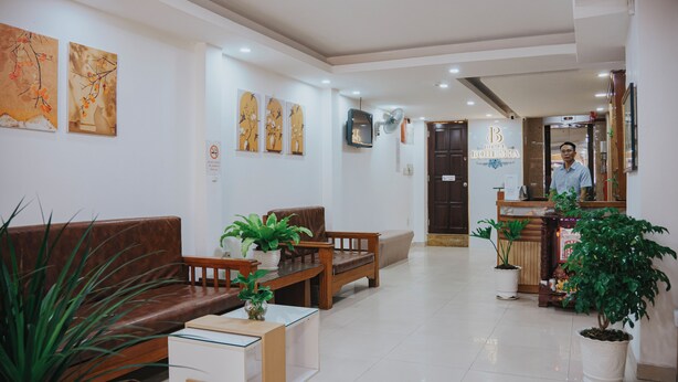 A hotel lobby with a reception desk, seating area, and potted plants. - Bohemia Hotel (Ho Chi Minh City)