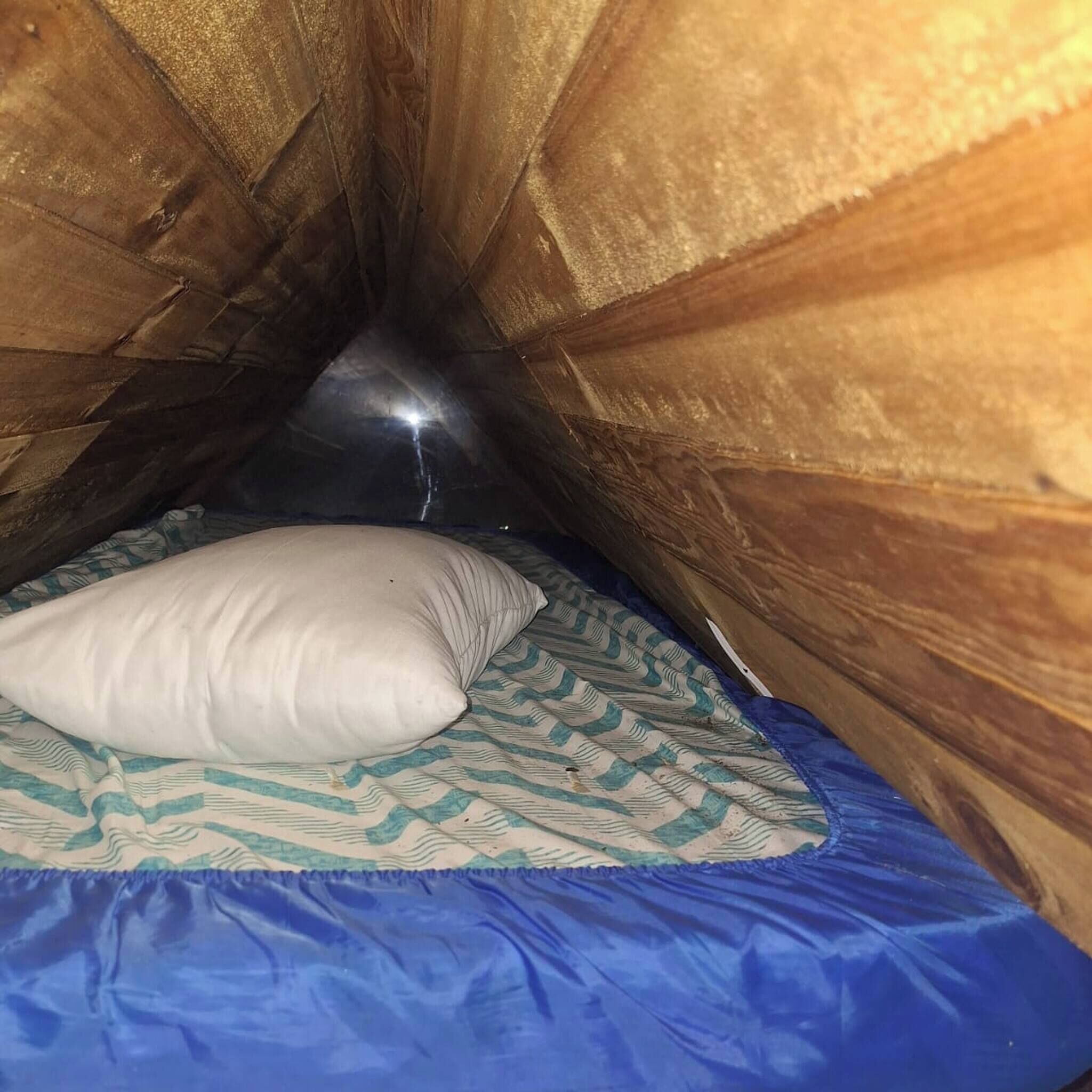 Uma cama beliche com colcha estampada e travesseiro.