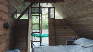A loft-style bedroom with a bunk bed, a small table, and a bench.