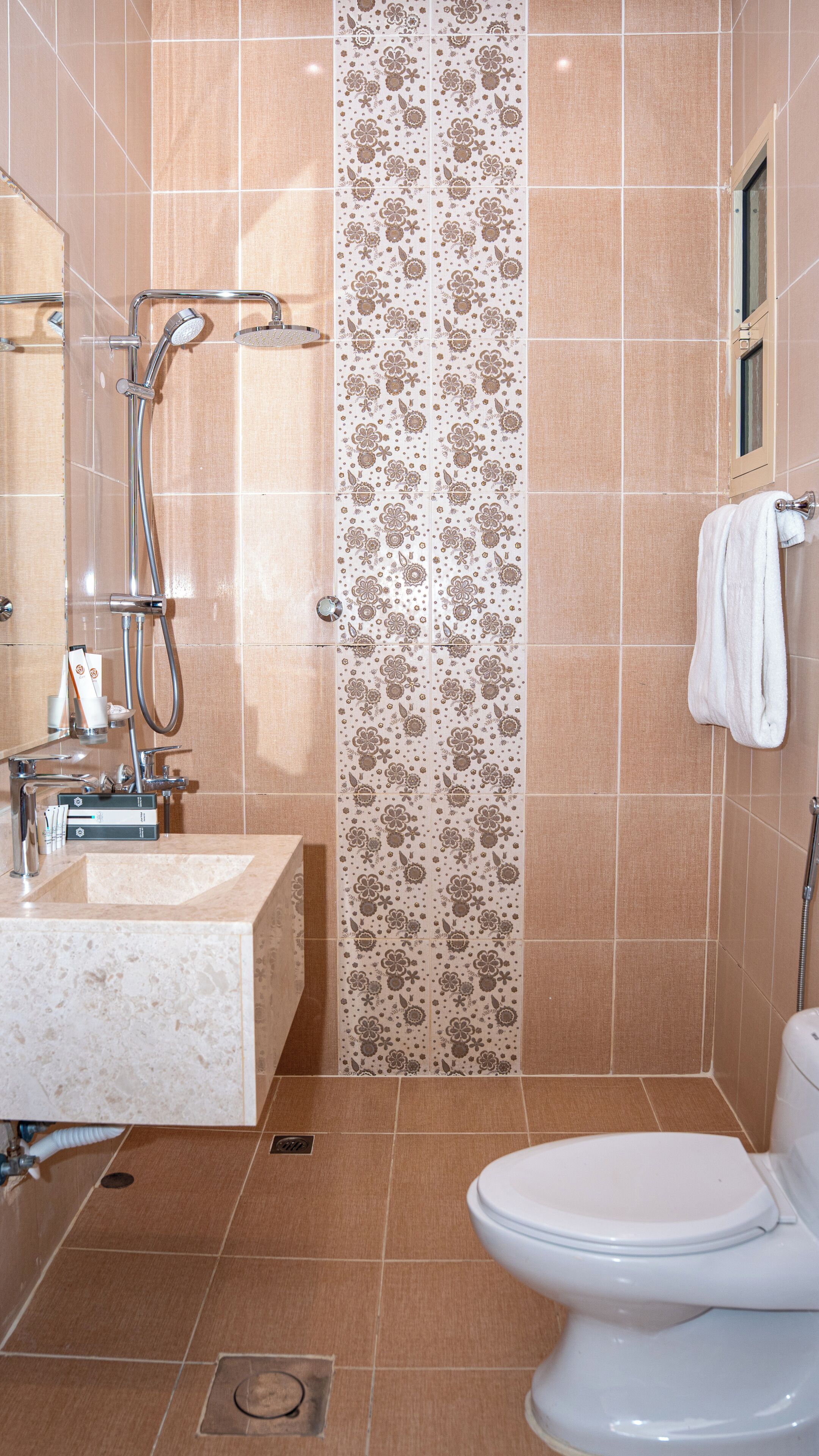 A bathroom with a shower, sink, and toilet.