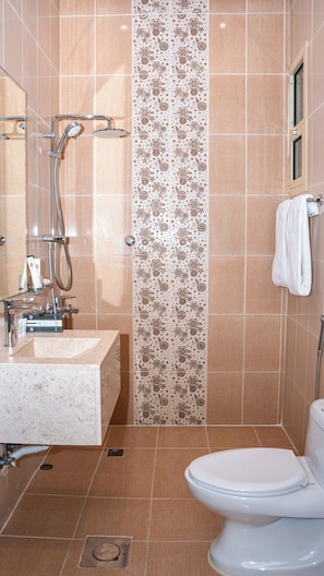 Ein Badezimmer mit Dusche, Waschbecken und Toilette.