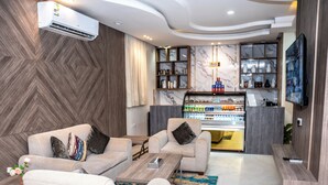 Un moderno espacio de estar con sofás, una mesa de centro, televisor y un minibar.