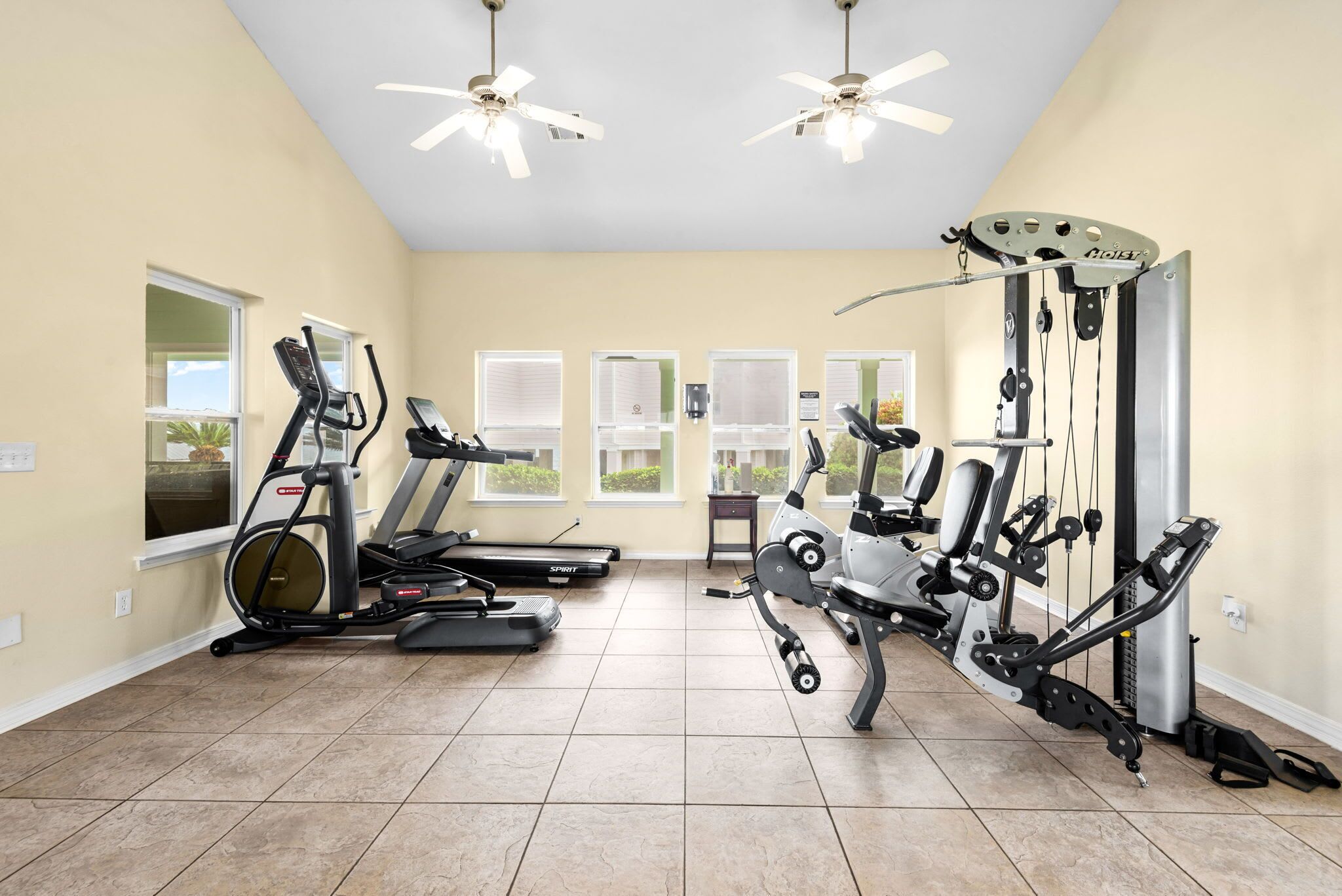 Un gimnasio en casa con cintas de correr, elípticas y equipo de pesas.