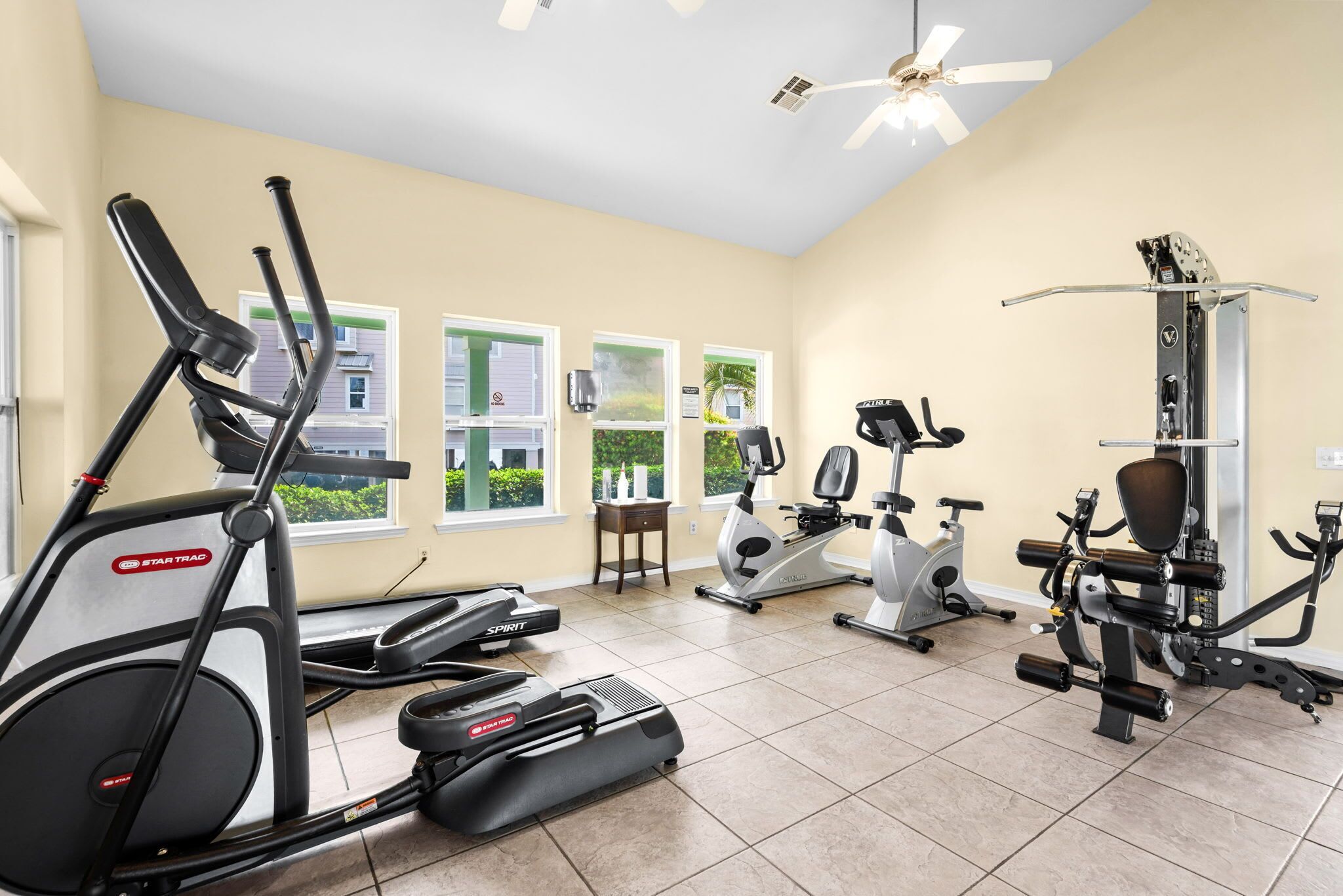 Une salle de sport équipée de tapis de course, de vélos d’appartement et d’appareils de musculation.