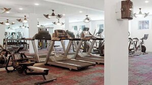 Un gimnasio con cintas de correr, bicicletas estáticas y máquinas de pesas.