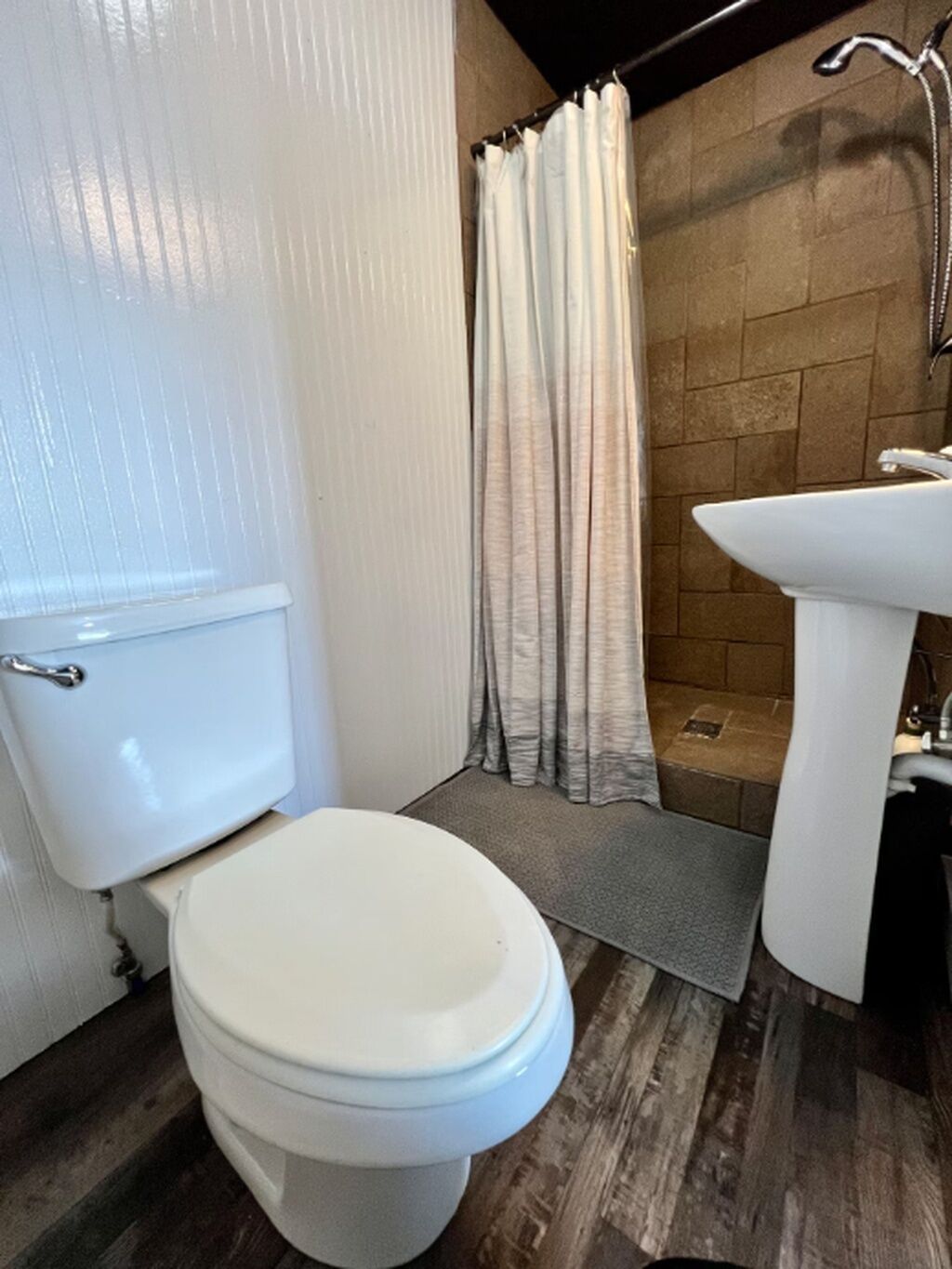 Une salle de bain avec des toilettes, une douche et un lavabo.