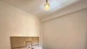 Une chambre à coucher avec un lit, une table de chevet et un luminaire suspendu.