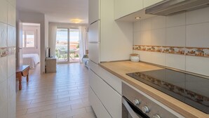 Een moderne keuken met witte kasten, een houten aanrecht en een groot fornuis.
