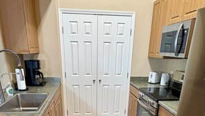 A kitchen with a sink, stove, microwave, and refrigerator. - Heated Pools, King Bed, Fast Wi-Fi – Gated East Mesa 2BR Condo with Balcony (Mesa)