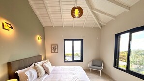 Une chambre à coucher avec un lit, une chaise, une fenêtre et un luminaire au plafond.