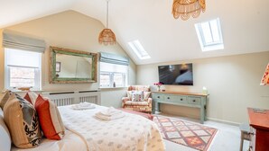 A bedroom with a bed, a chair, a TV, a dresser, and a window. - St Mary’s Mews - A Charming York Retreat (York)