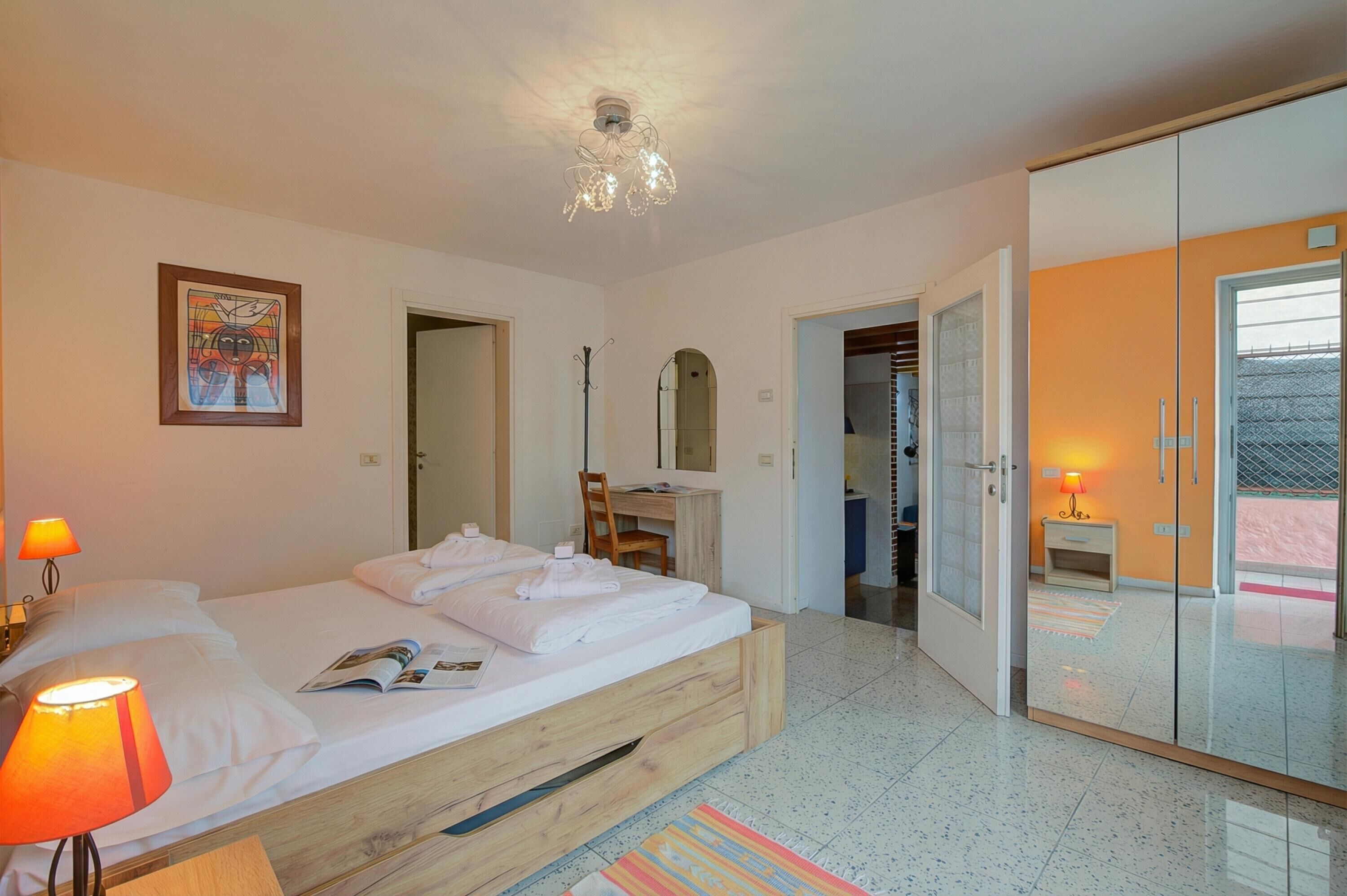 Une chambre d’hôtel comprenant un lit, des lampes de chevet, un bureau, un miroir et une armoire.
