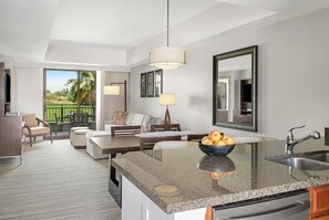 A modern hotel room with a kitchen island, dining area, and a large window with a view of greenery. - 1 Bedroom sleeps 4 Available for First Weekend Of Coachella 2026 (Palm Desert)